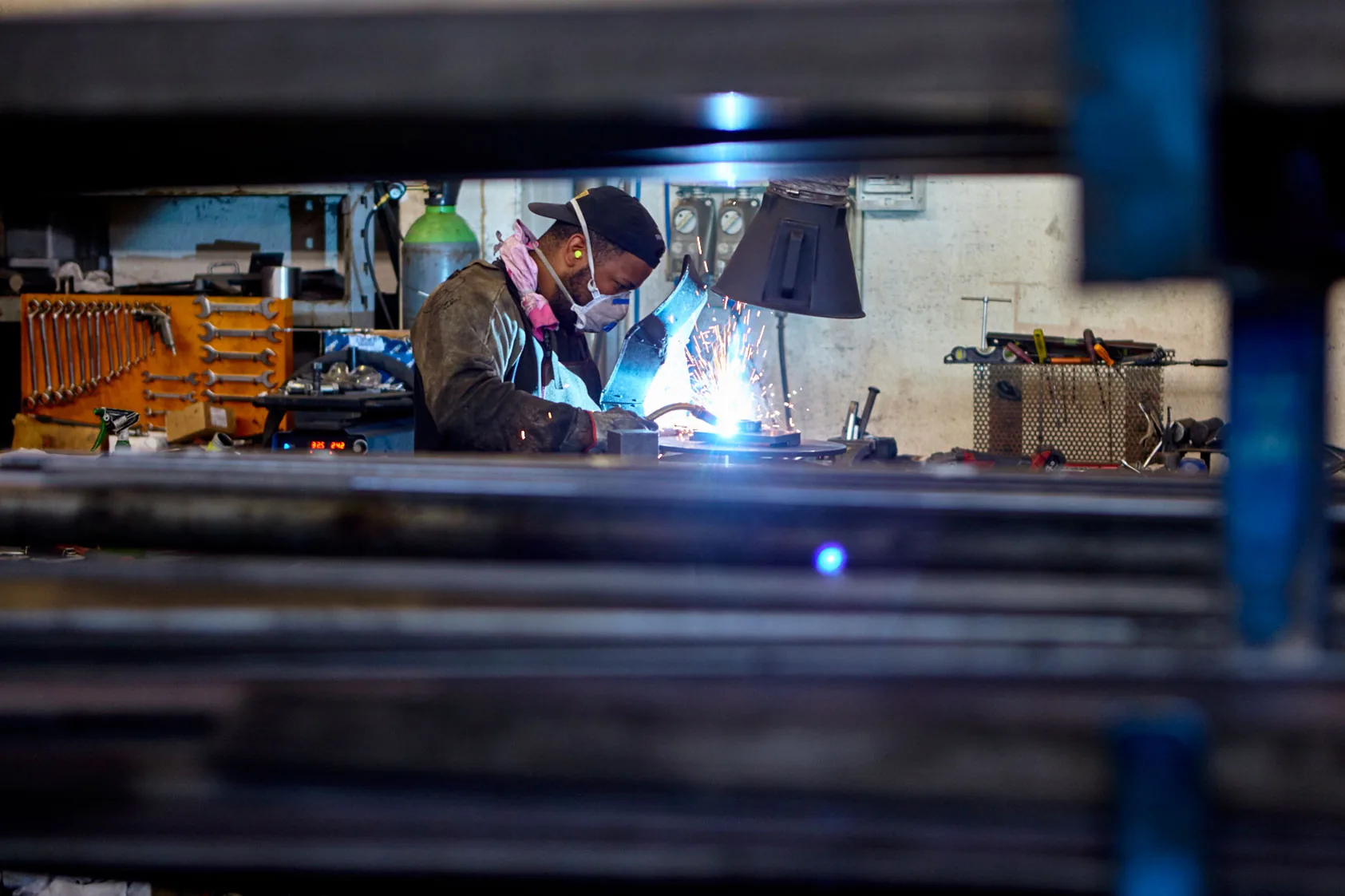 TURCHI kaynak bölümü — uzman kaynakçı ark ve kıvılcımlarla hidrolik kazık çakıcı şasisi üzerinde çalışıyor