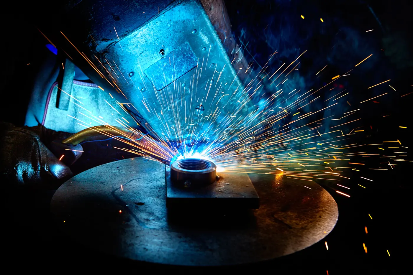 TURCHI hidrolik bileşeni üzerinde özel kaynak — üretim alanında ark ve kıvılcımlar